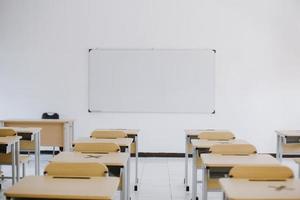 aula moderna vacía con sillas, escritorios y pizarra foto