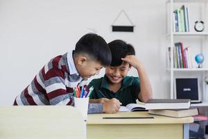 estudiantes de primaria asiáticos que estudian e interactúan en clase foto