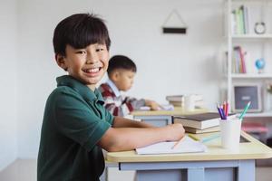 estudiante asiático sonriente mirando a la cámara en una clase
