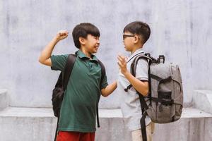 estudiante asiático siendo intimidado en la escuela o niños peleando o atacando a su compañero de clase en la escuela foto