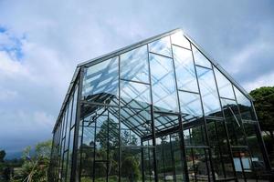 Modern greenhouse against the blue sky with clouds photo