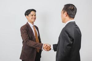 joven y apuesto hombre de negocios asiático hace un apretón de manos con su pareja foto