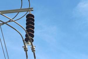 Close-up of High voltage electrical insulator with blue sky background. photo