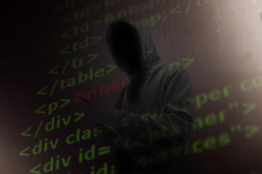 Computer hacker in mask and hoodie over abstract Data thief background. photo