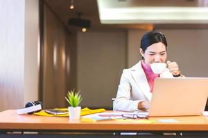 Relax business asian woman drink coffee in office when working. photo