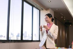 Businesswoman take a break drink coffee office with window light. photo