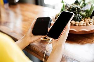 Rear view of woman use smart phone and portable mobile charger. photo