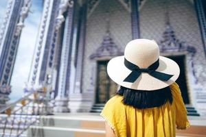 Thailand travel rear view of adult tourist woman at local asia buddhist temple. photo