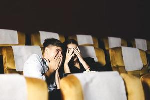 Love adult caucasian couple man and woman see scary movie in theater photo