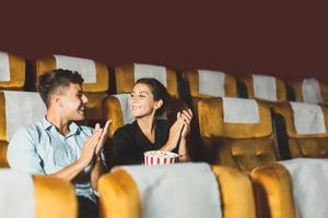Happy young adult caucasian man and woman business couple watching cinema. photo