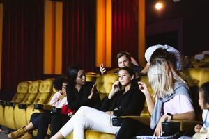 Caucasian using mobile phone and loud talking in movie theater. photo