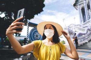 mujer asiática adulta usa máscara para proteger la foto selfie de virus con un nuevo estilo de vida normal