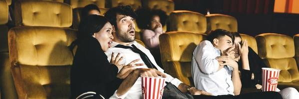 hombres caucásicos con diversidad pareja viendo cine en el teatro foto