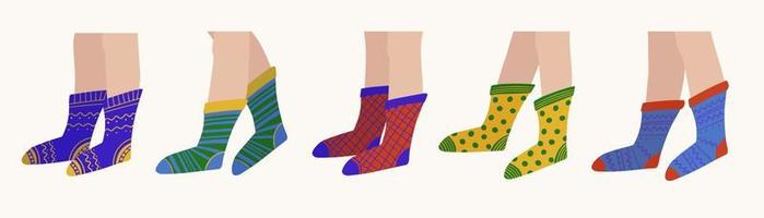 Multicolored cozy knitted socks on people's feet made of natural cotton vector