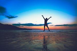 Asian man fun jumping and happy with beach tourism. summer photo