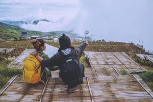 amantes mujeres y hombres asiáticos viajar relajarse en las vacaciones. ver mapa explorar las montañas foto