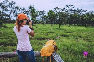 Asian woman travel nature. Travel relax. Photography Cucumber sessilis flower field. photo