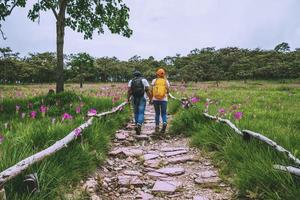 Amante mujer y hombre asiático viajes naturaleza. viajar relajarse. fotografía campo de flores de pepino sessilis. foto