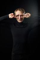 Portrait of determined goodlooking man wearing black shirt, black background. photo