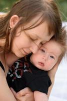 Young mother hugging cute baby outdoor photo