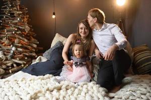 Father mom and their little one year old daughter have fun together before christmas. photo