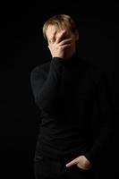 Portrait of determined goodlooking man wearing black shirt, black background. photo