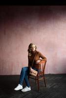 Vertical image of smiling woman pointing up and looking at camera photo