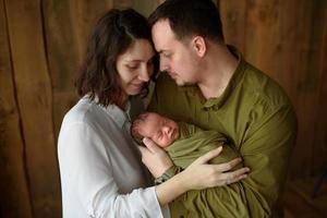 Parents hold their newborn son in their arms photo