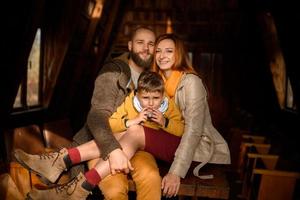 una familia feliz se sienta en los escalones frente a la entrada de la casa. foto