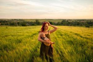 A mother tenderly holds her three month old son in her arms in a wheat field. photo