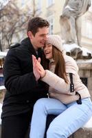 Young guy and girl in winterwear enjoying snowfall photo