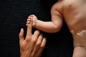 Little boy holds father by thumb photo