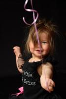 día de la fiesta de cumpleaños de la niña del primer año. globos y vacaciones en interiores. cumpleaños del niño niña bonita en su primer vestido negro foto