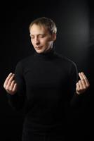 Portrait of determined goodlooking man wearing black shirt, black background. photo