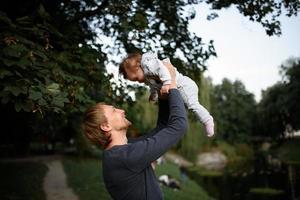 joven padre divirtiéndose con su pequeña hija en el parque foto