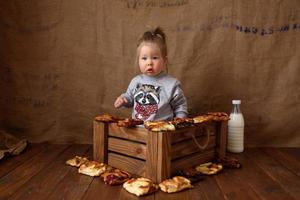 Little girl in the kitchen eats sweet pastries. photo