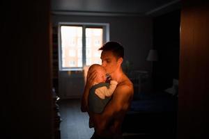 An adorable baby with father sonsoling close to the window photo