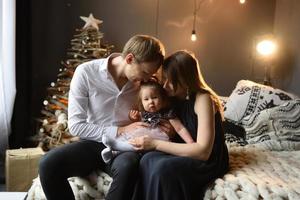 Father mom and their little one year old daughter have fun together before christmas. photo