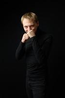 Portrait of determined goodlooking man wearing black shirt, black background. photo