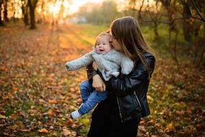 joven madre y su niña pequeña en los campos de otoño foto