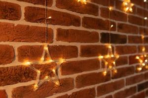 Christmas star hanging on a red brick wall. Christmas garland. photo