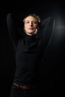 Portrait of determined goodlooking man wearing black shirt, black background. photo