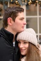 Young guy and girl in winterwear enjoying snowfall photo