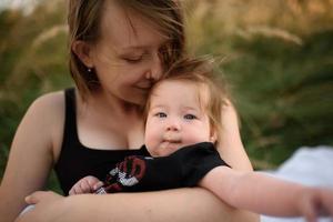 Young mother hugging cute baby outdoor photo