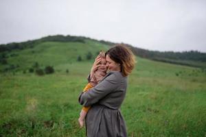 Mom, dad and daughter. Parents Hold baby by hands and go towards the camera. photo