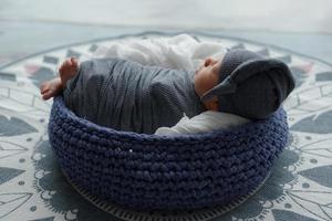 Newborn baby boy wrapped in gray fabric photo