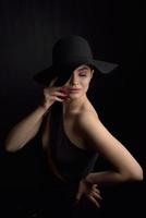 Beautiful woman in hat. Retro fashion. Dark Background. photo
