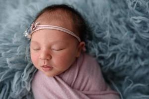 Portrait of a sleeping newborn baby in blue fur photo