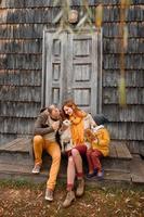 a happy family sits on the steps in front of the entrance to the house. photo