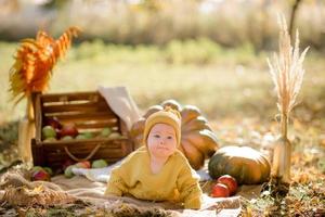 Cute little girl sitting on pumpkin and playing in autumn forest photo